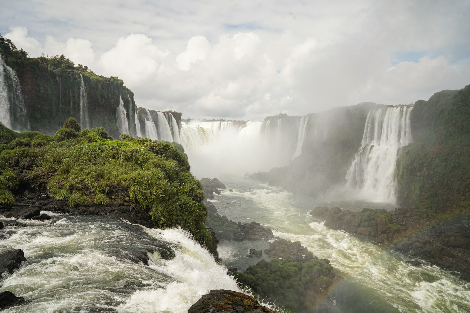 The tiered cascades of the Iguacu Falls in a cloud of mist