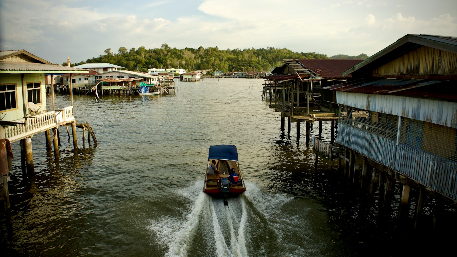 A water taxi speeding through the stilt houses of the Kampong Ayer water village, Brunei