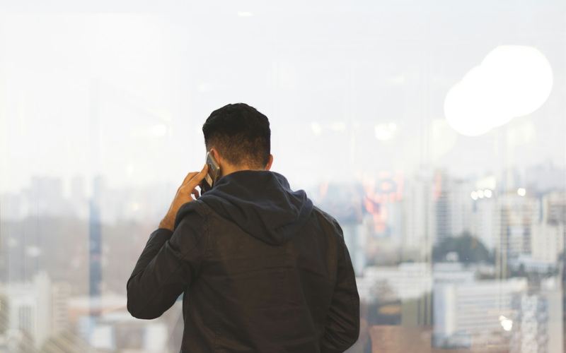 A man on a phone call looking over a city