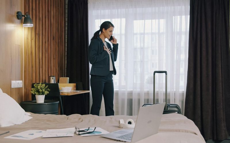 A traveler on a phone call in a hotel room