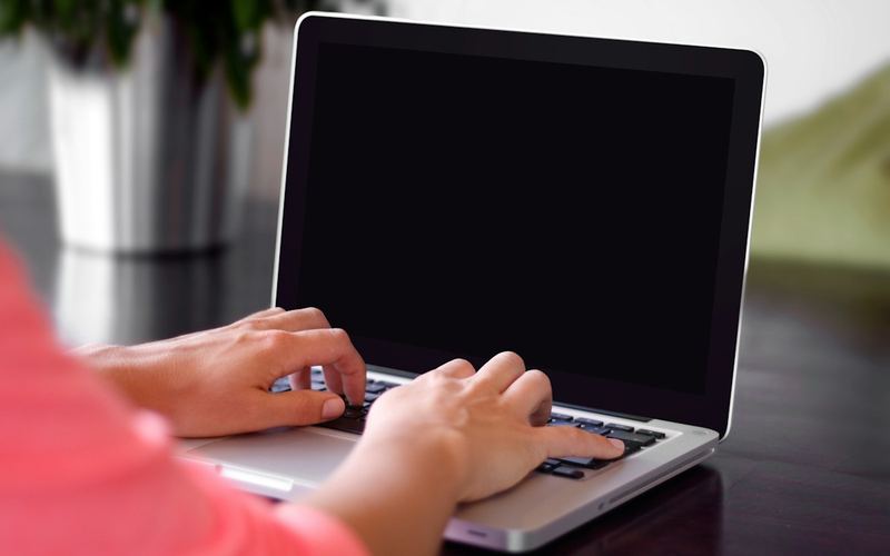 Hands typing on a laptop