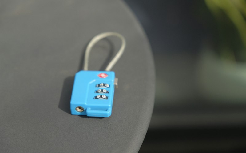 A small blue combination lock on a grey surface