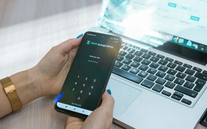 A phone showing a code screen next to a laptop