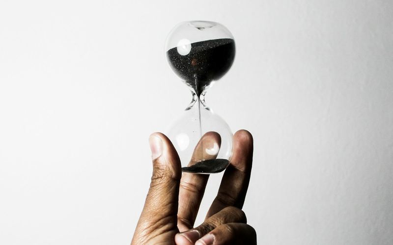 A hand holding an hourglass