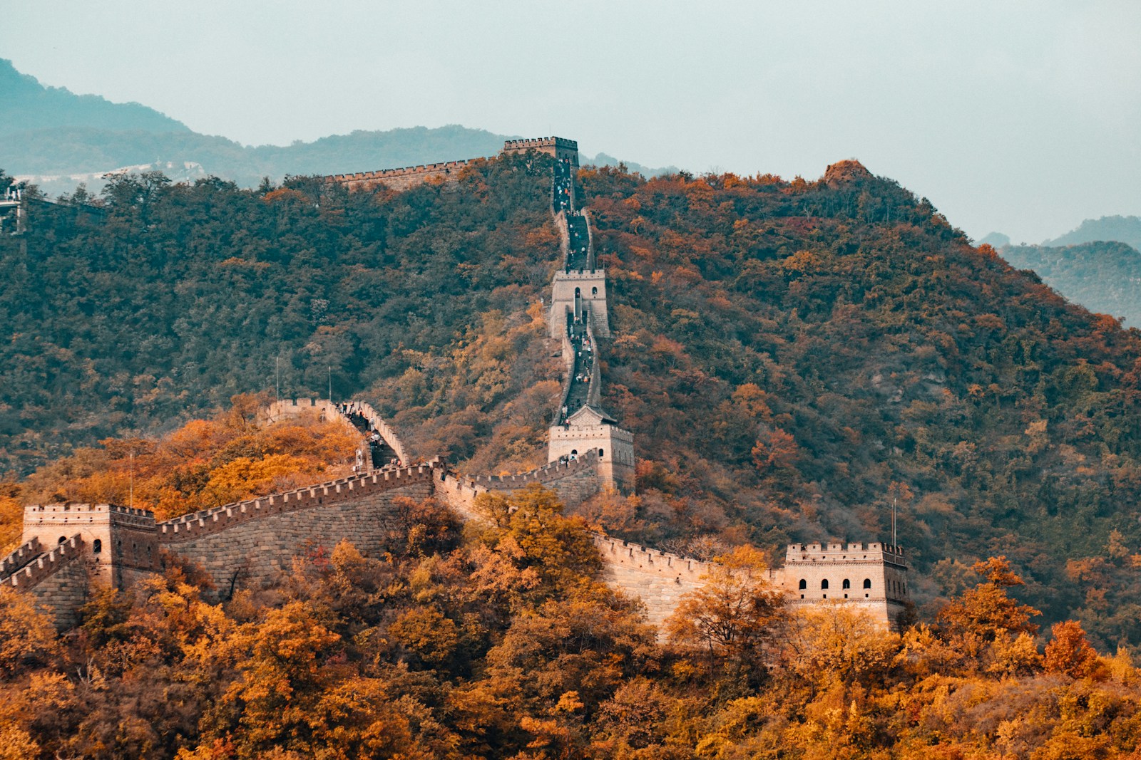 The Great Wall of China winding over forested autumn hills
