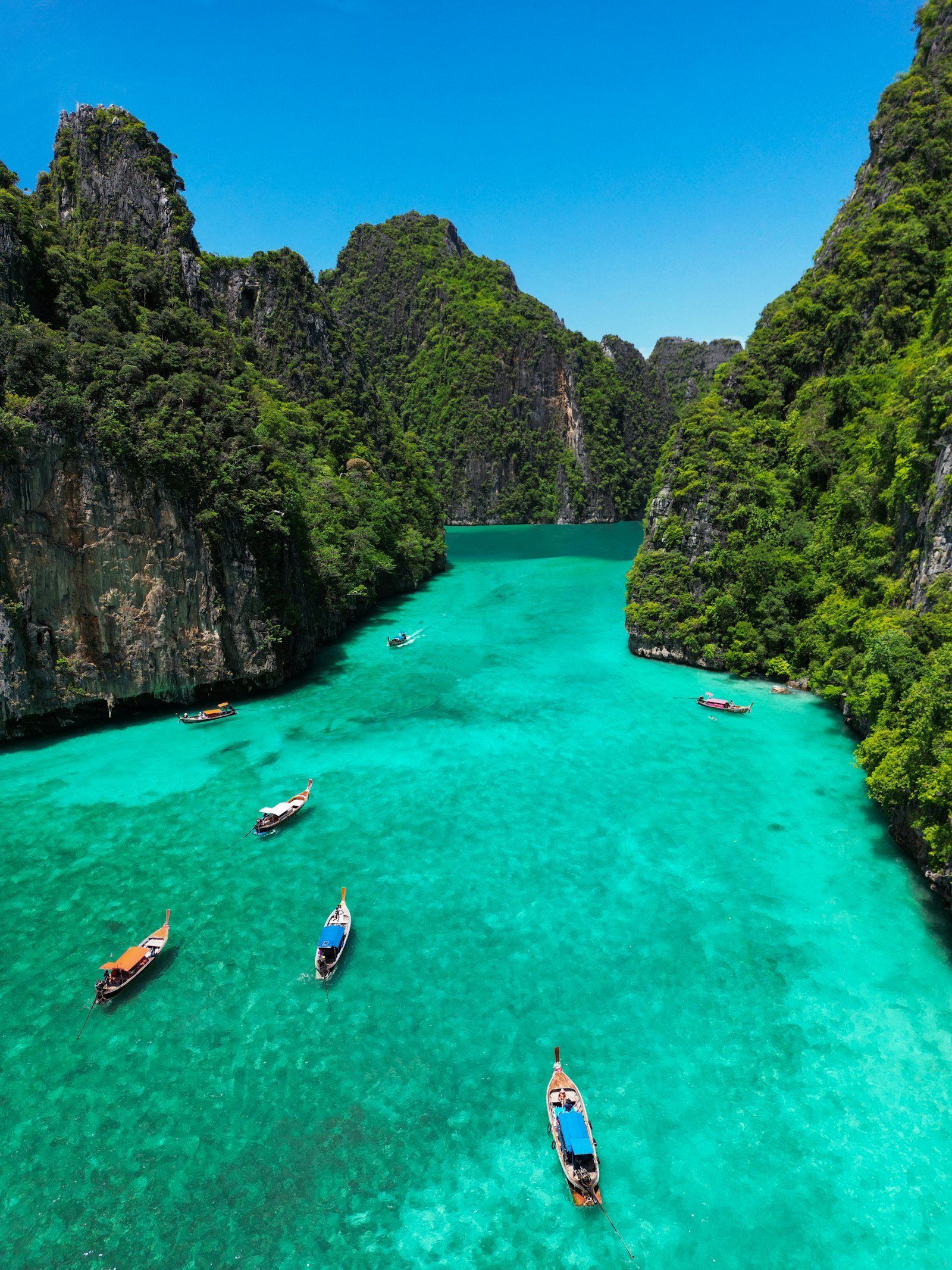 Longtail boats in the turquoise Pileh Lagoon at Phi Phi, Thailand