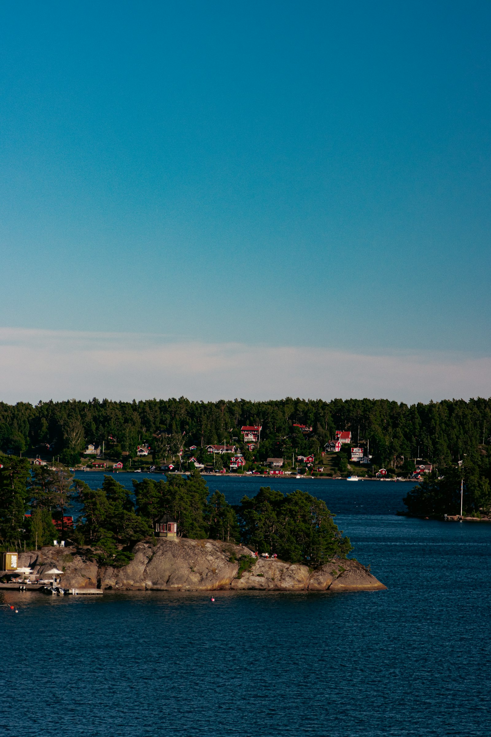 A small island with a red cottage in the Swedish archipelago