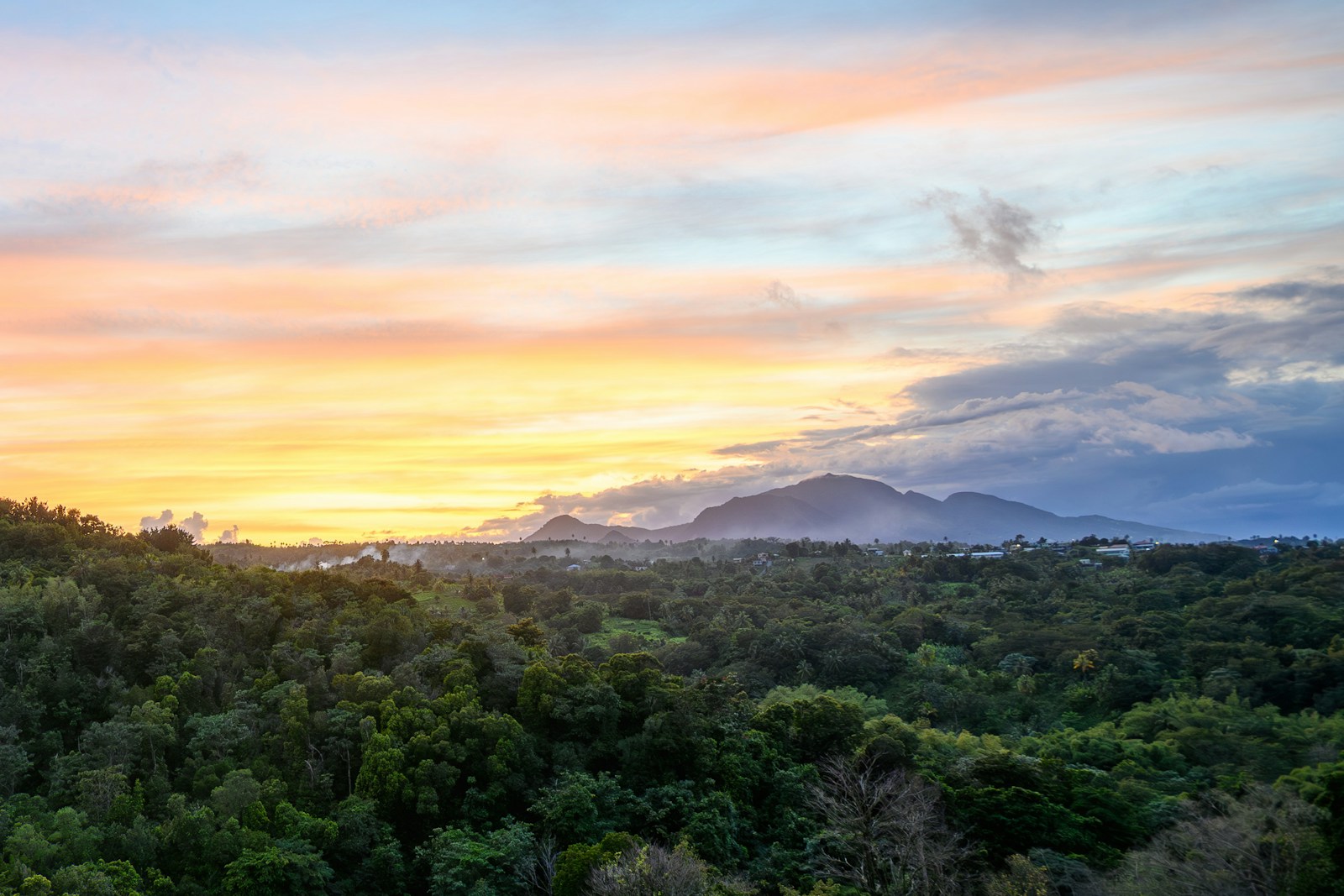 Rainforest and volcanic mountains at sunset with rising steam, Dominica