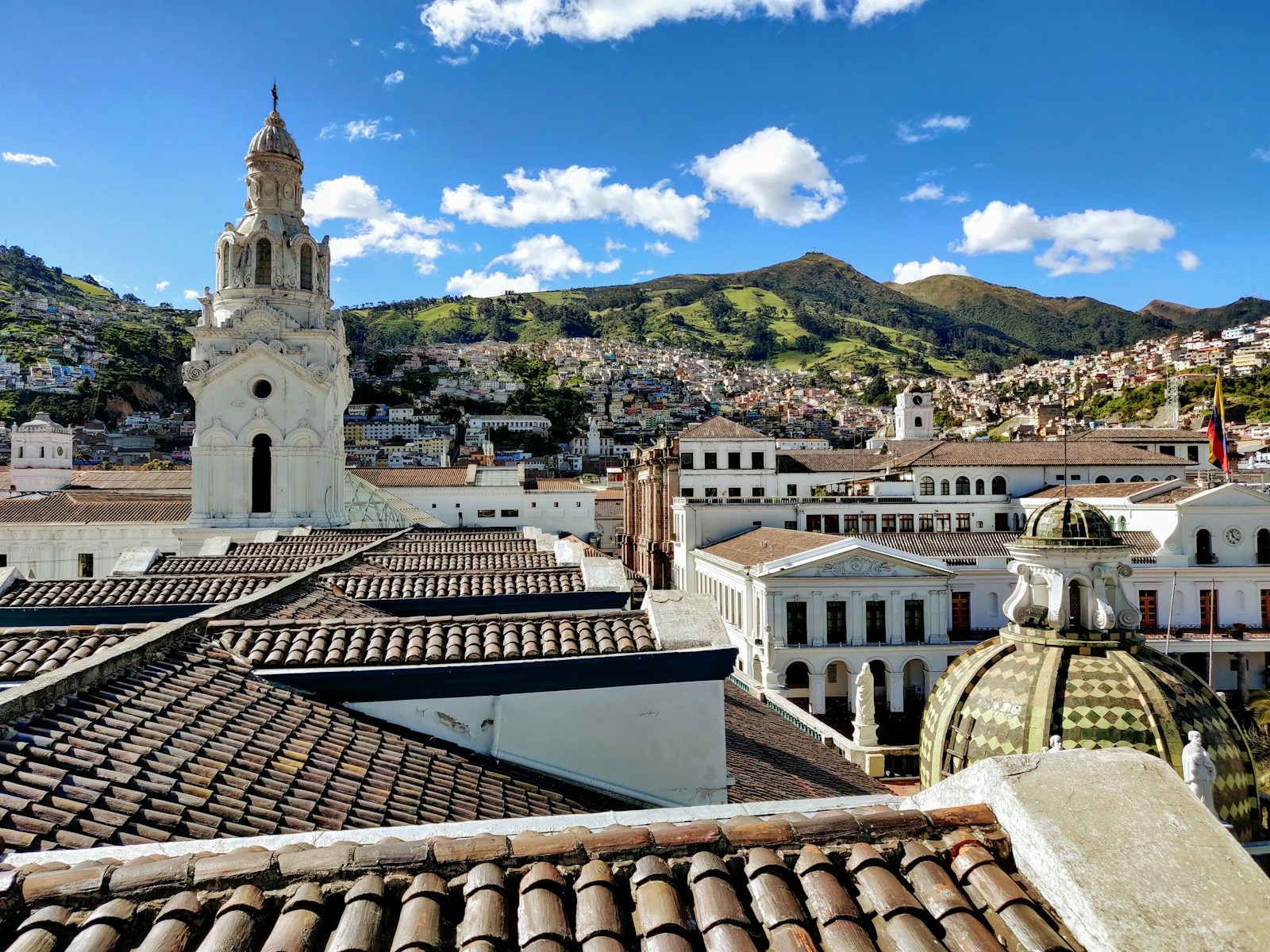 The terracotta rooftops and church towers of colonial Quito with the Andes behind