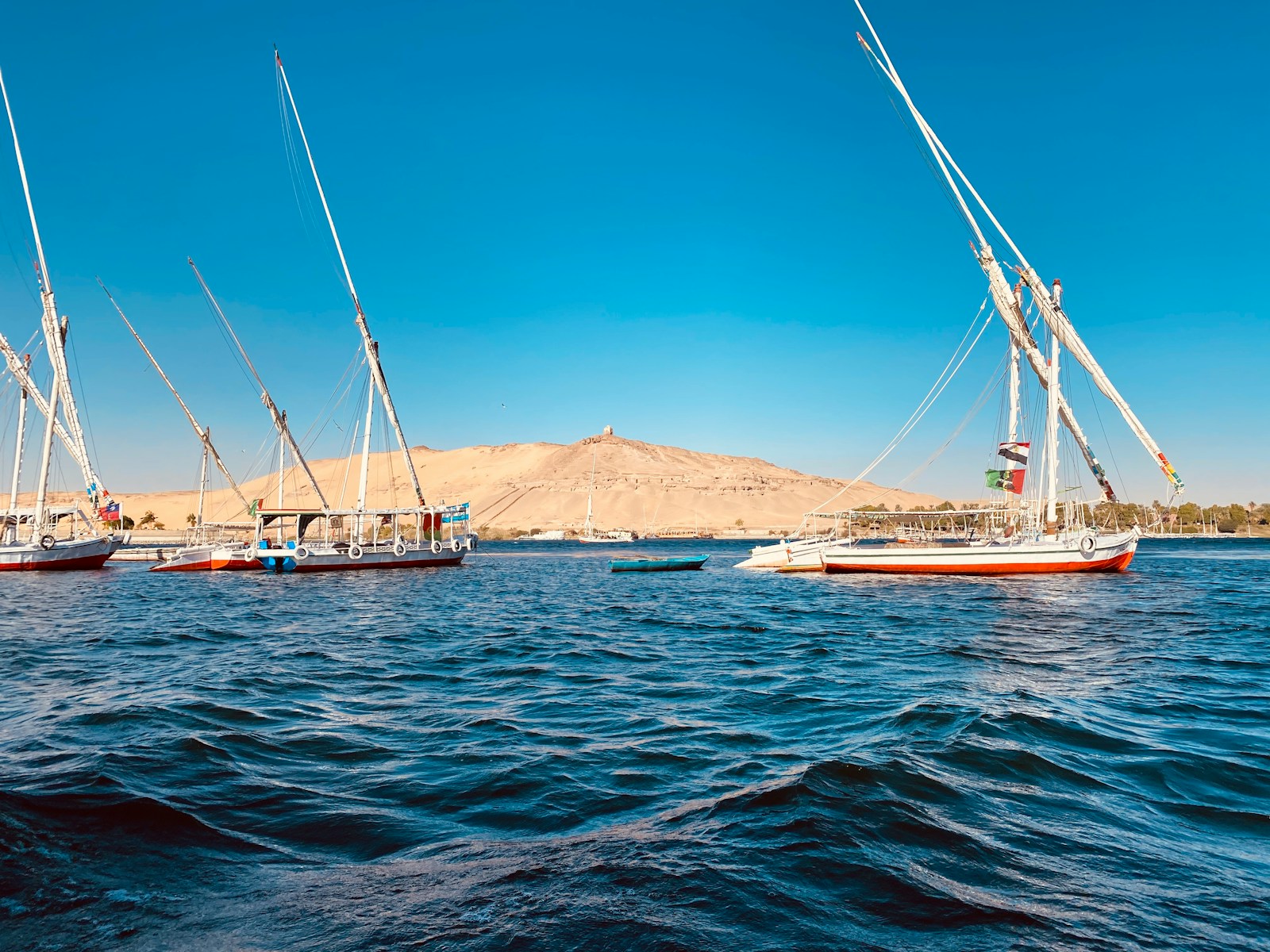 Feluccas moored on the blue Nile at Aswan with the desert bank beyond