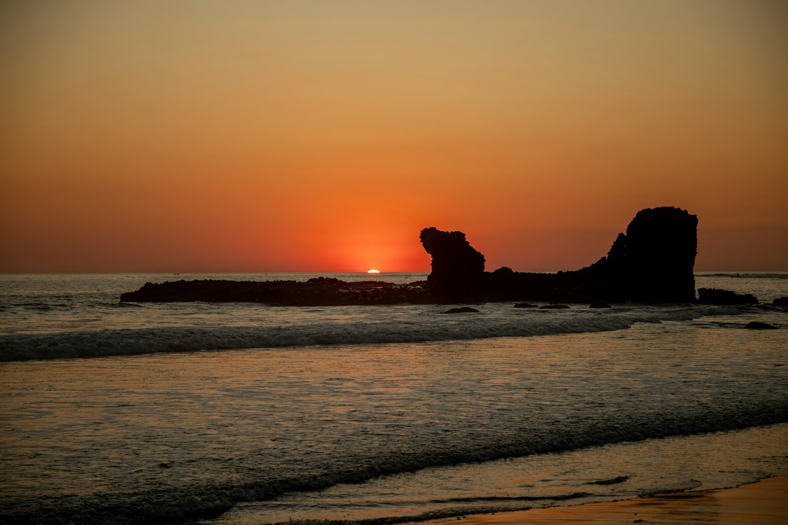 The El Tunco rock formation silhouetted at sunset on El Salvador's surf coast