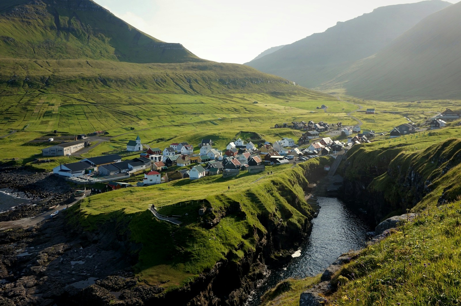 The green valley village of Gjogv on a fjord in golden light, Faroe Islands
