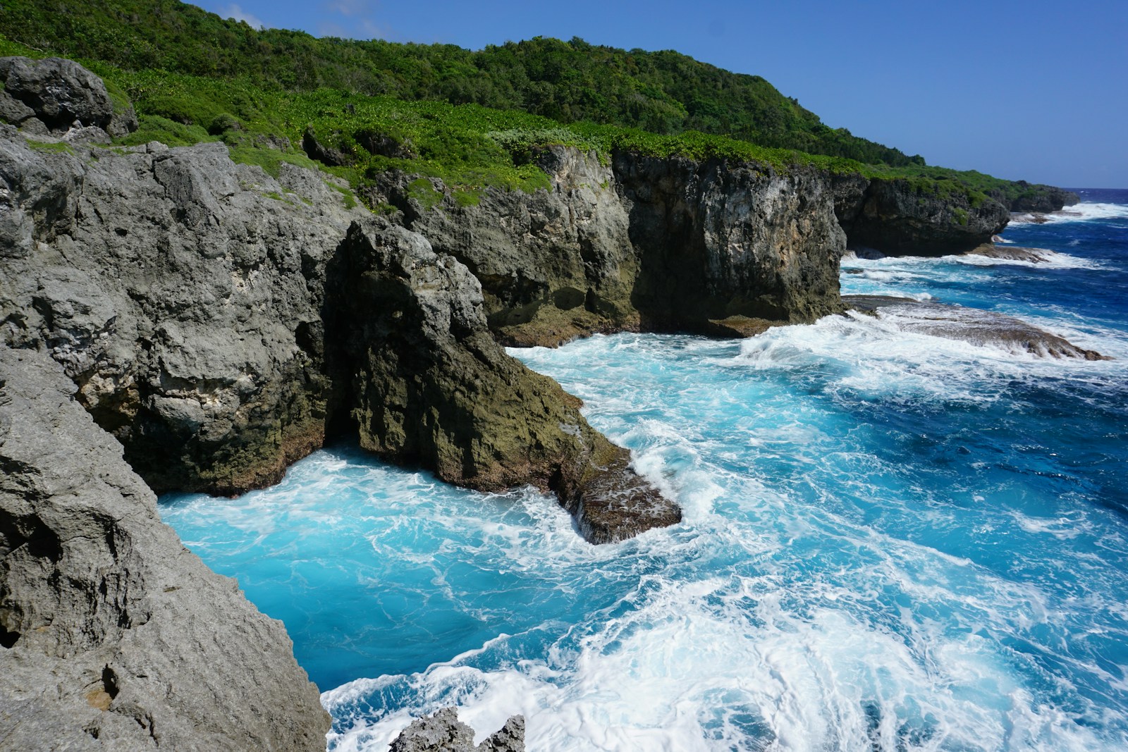 Rugged limestone sea cliffs and churning surf on the coast of Guam
