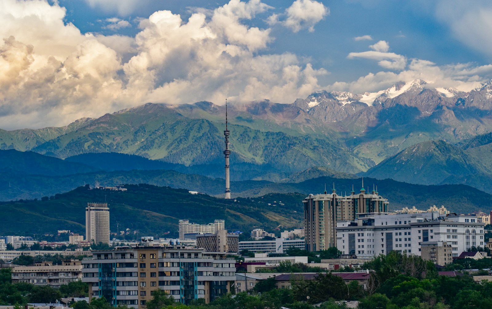 The Almaty city skyline and Kok-Tobe tower beneath the snow-capped Tian Shan mountains
