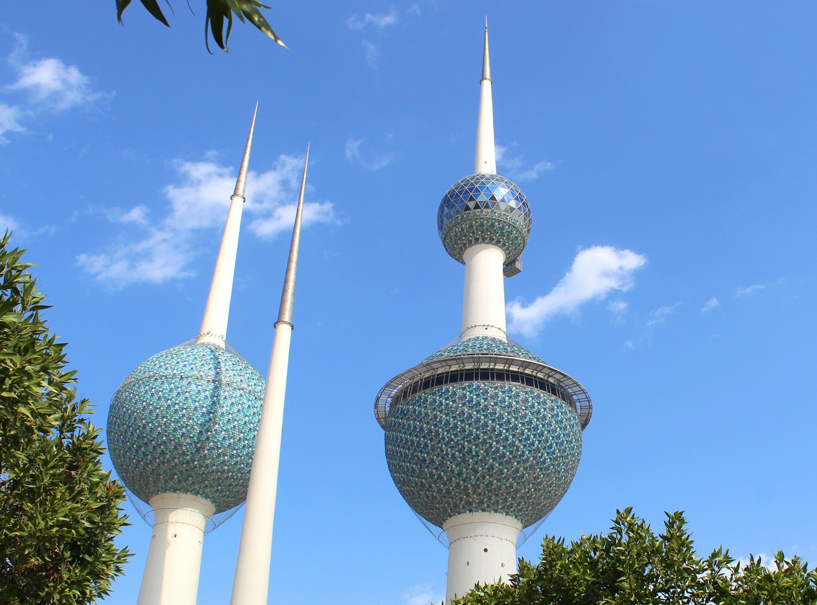 A close view of the blue-green mosaic spheres of the Kuwait Towers against a clear blue sky