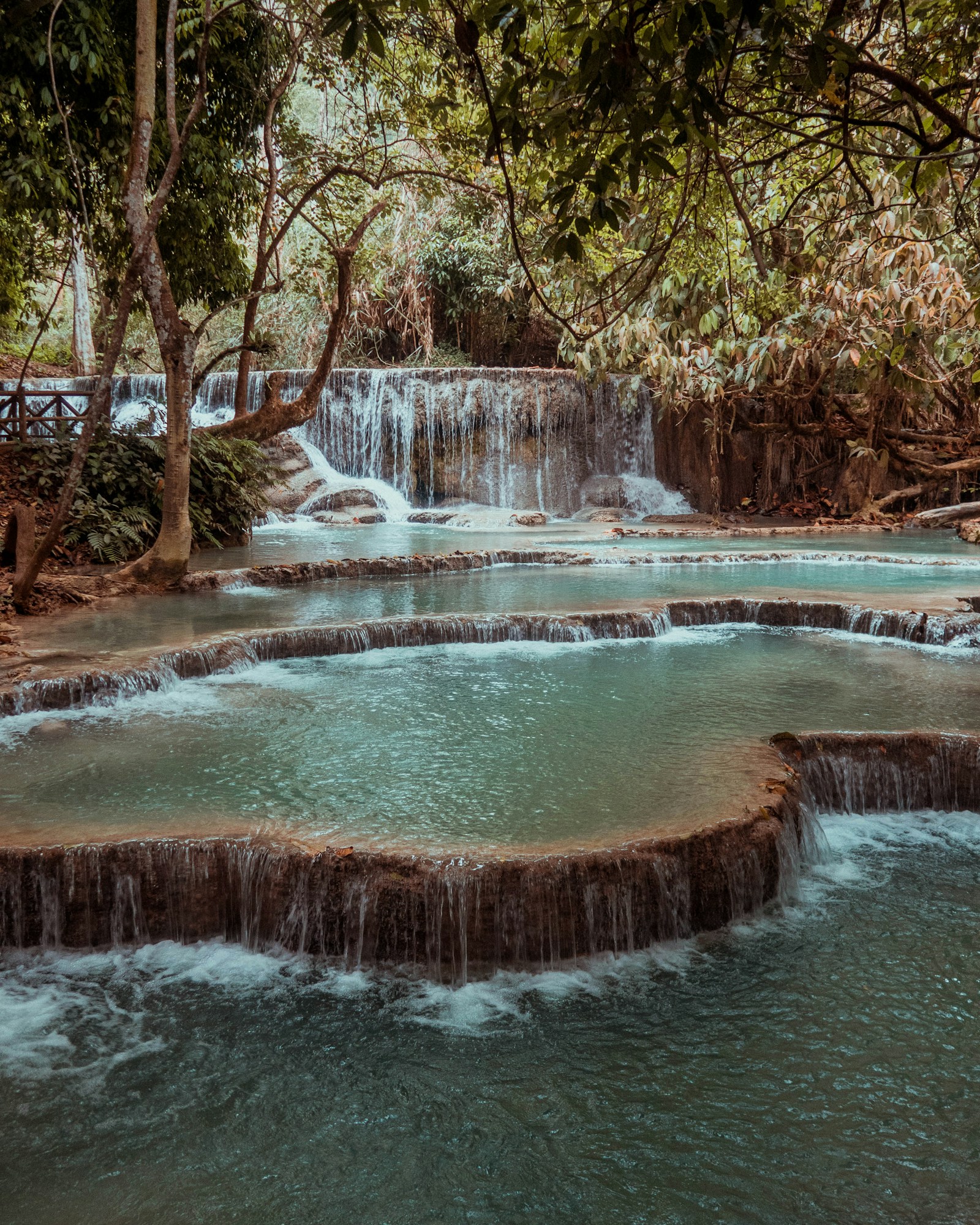 The turquoise terraced pools of Kuang Si Falls cascading through the jungle near Luang Prabang, Laos