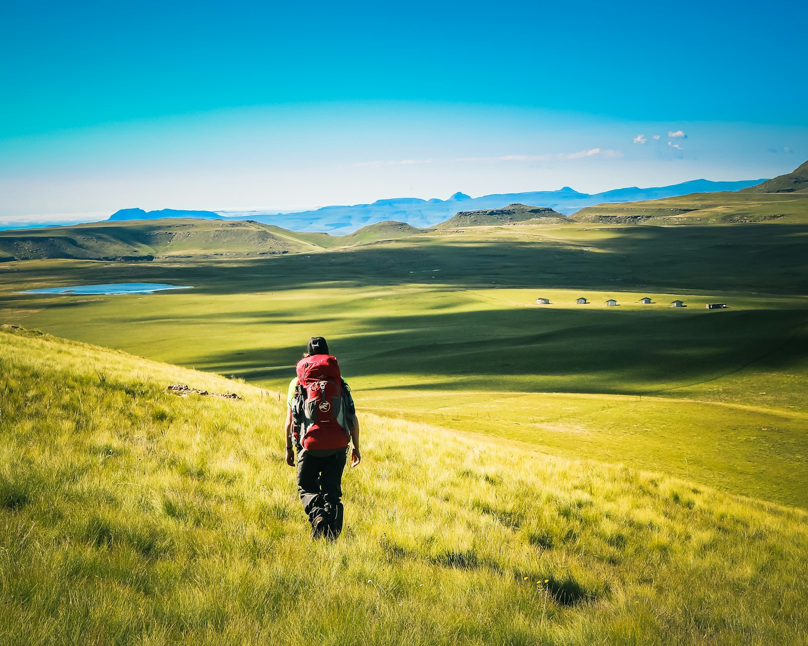 A hiker in the green highlands of Sehlabathebe, Maloti-Drakensberg, Lesotho