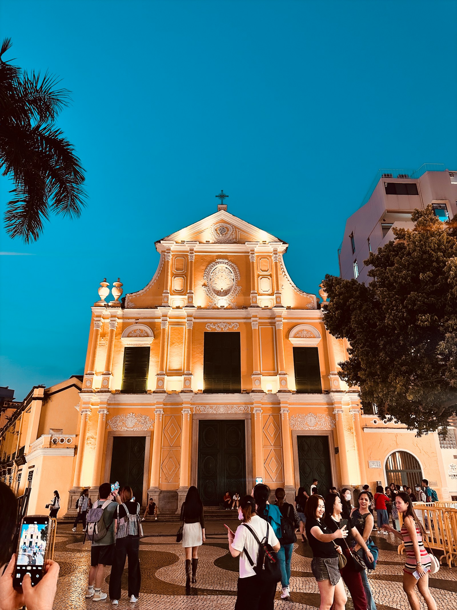 The yellow baroque facade of St. Dominic's Church lit at dusk in the historic centre of Macau