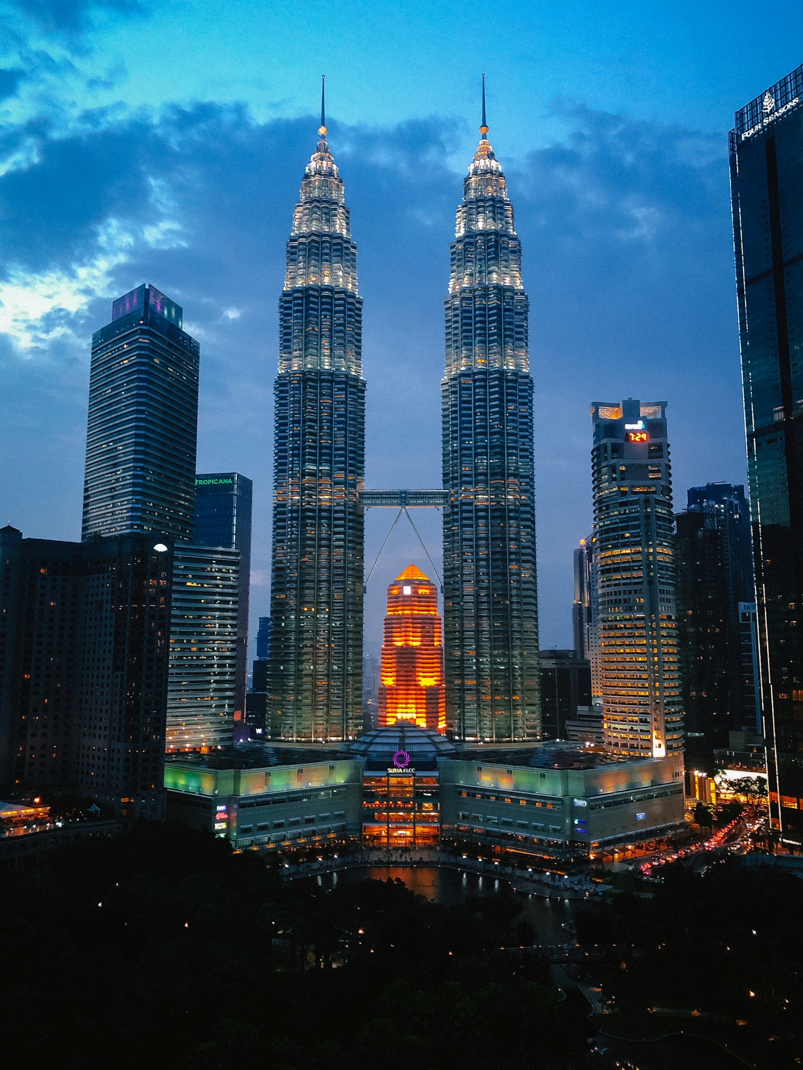 The illuminated Petronas Twin Towers and the Kuala Lumpur skyline at dusk