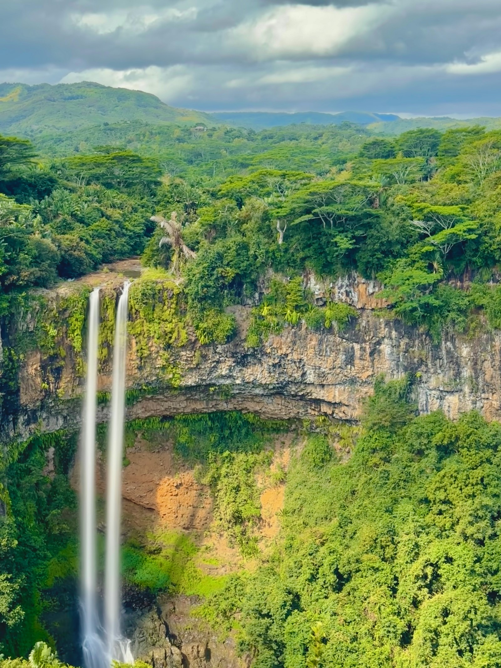 The twin cascade of the Chamarel waterfall plunging into a lush green gorge, Mauritius