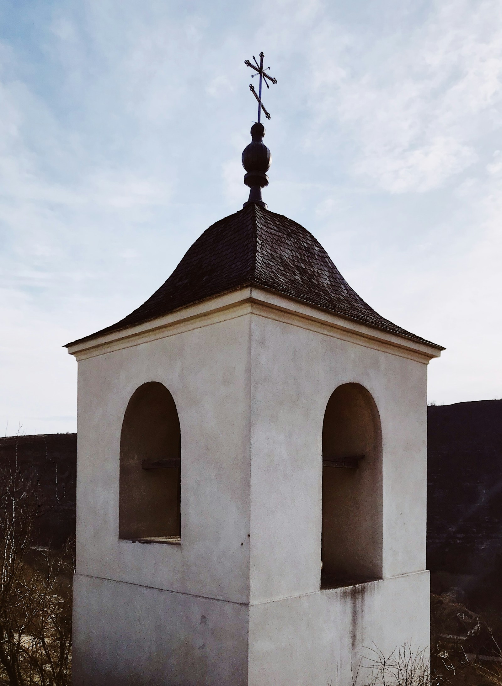 The white bell tower of the Orheiul Vechi monastery on the hills above the Raut river in Moldova