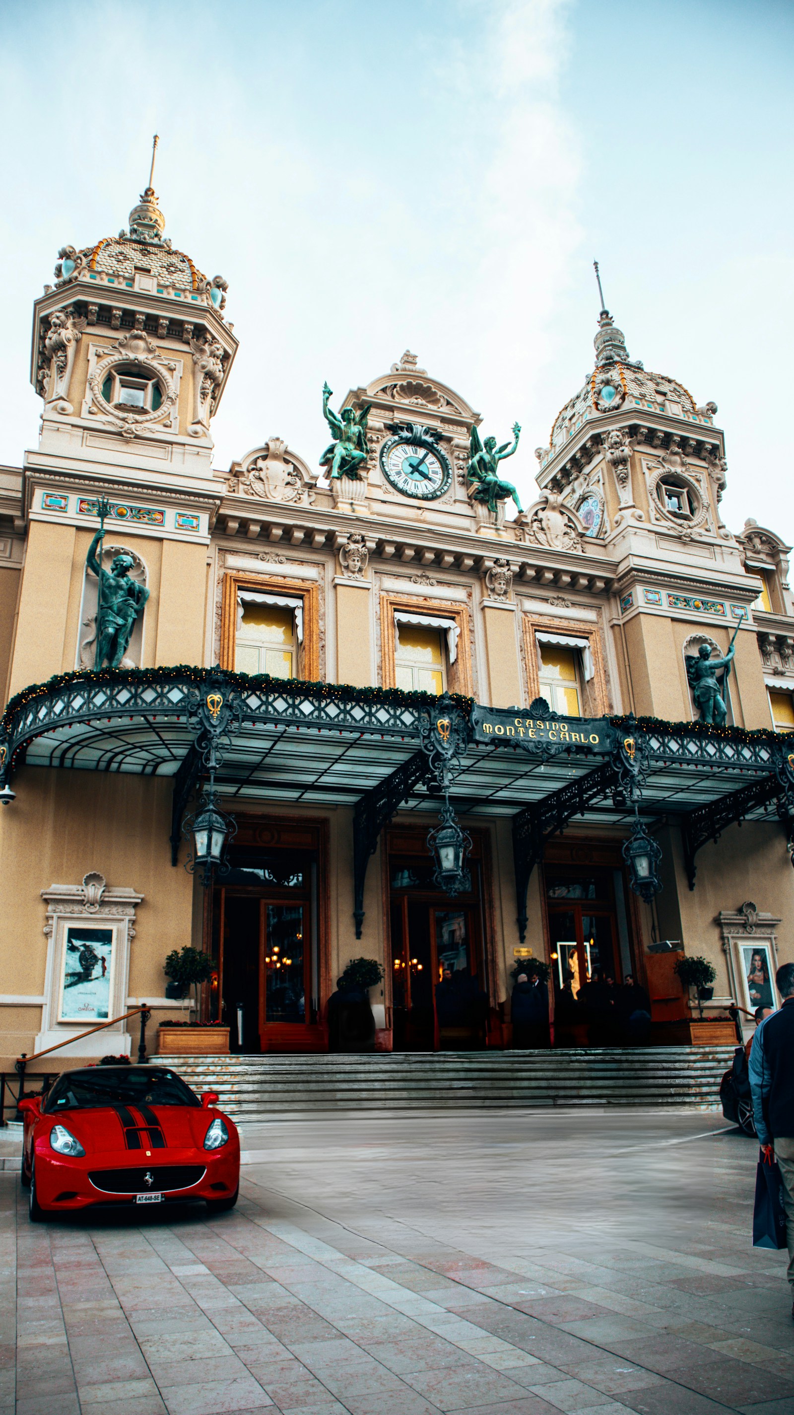 The Casino de Monte-Carlo with a red Ferrari parked in front, Monaco