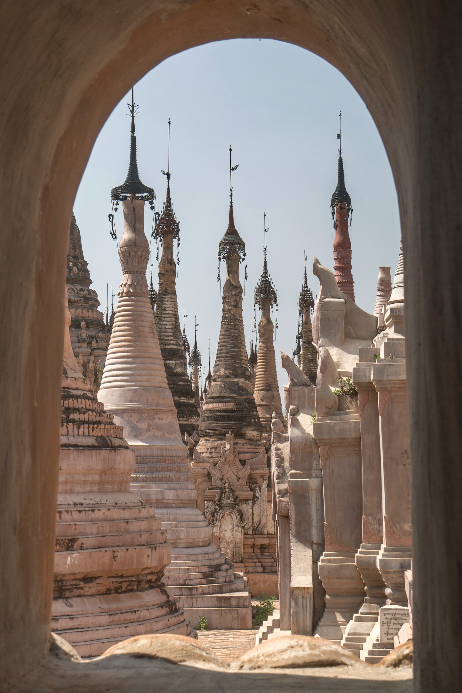 White stupas with elaborate spires framed through an arch, Myanmar