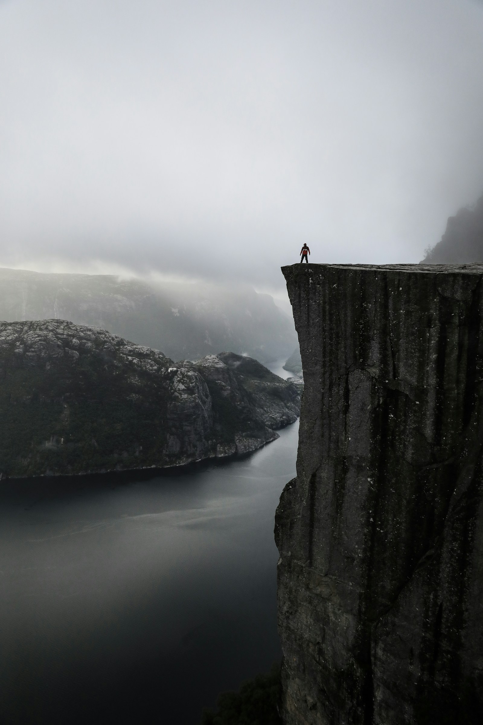A hiker on the edge of Preikestolen high above the Lysefjord in Norway