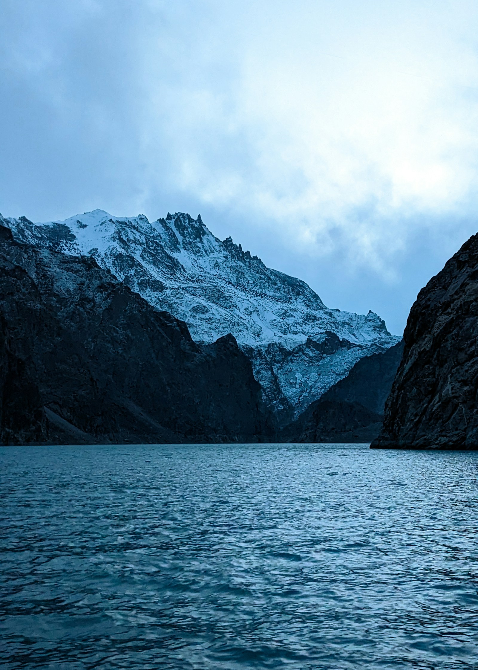 The turquoise water of Attabad Lake below snow-dusted mountains in the Hunza region, Pakistan
