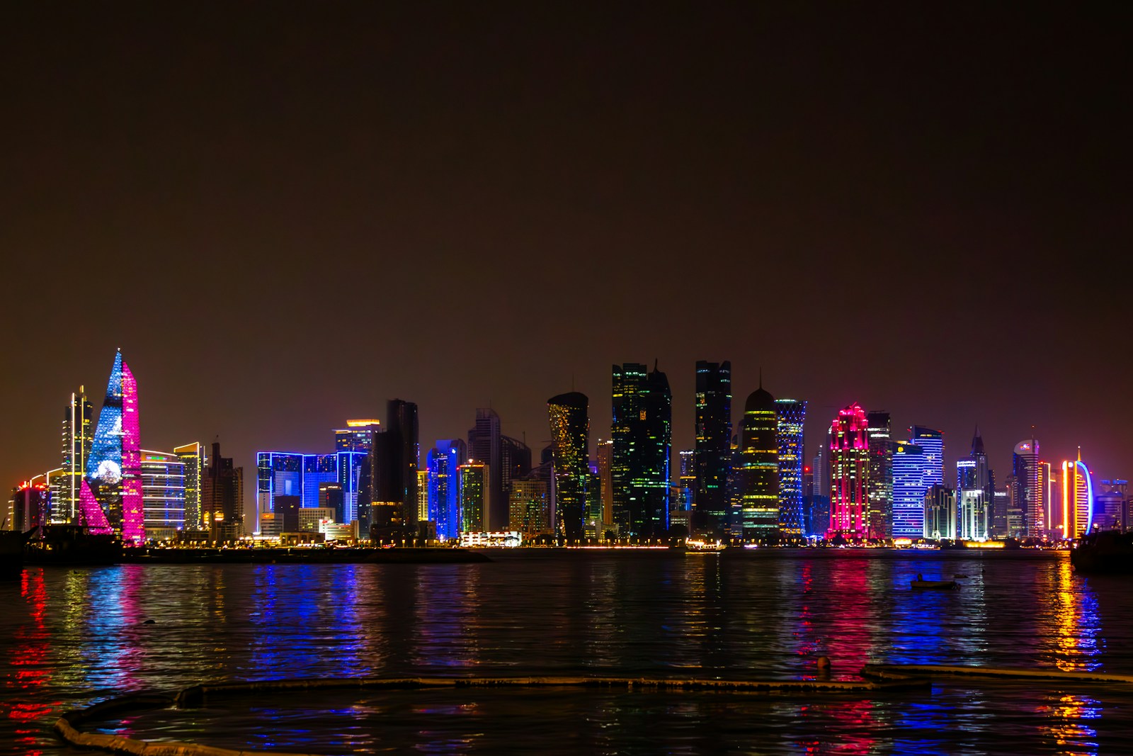 The illuminated West Bay skyscrapers of Doha reflected in the water at night