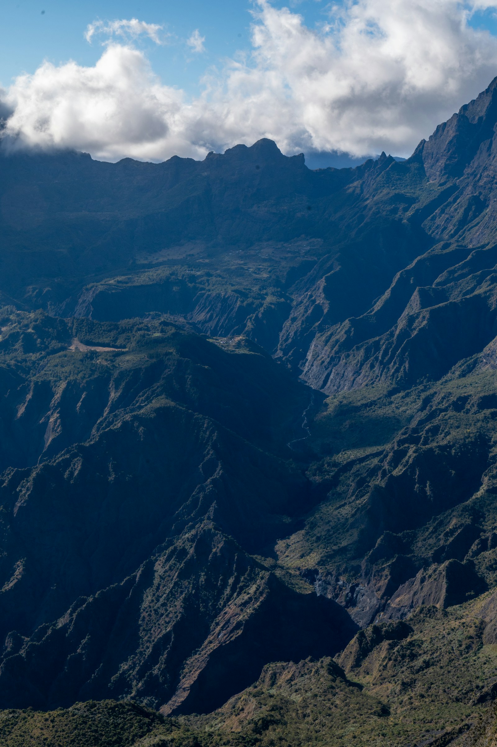An aerial view into a cirque of jagged green ridges and deep ravines, Reunion