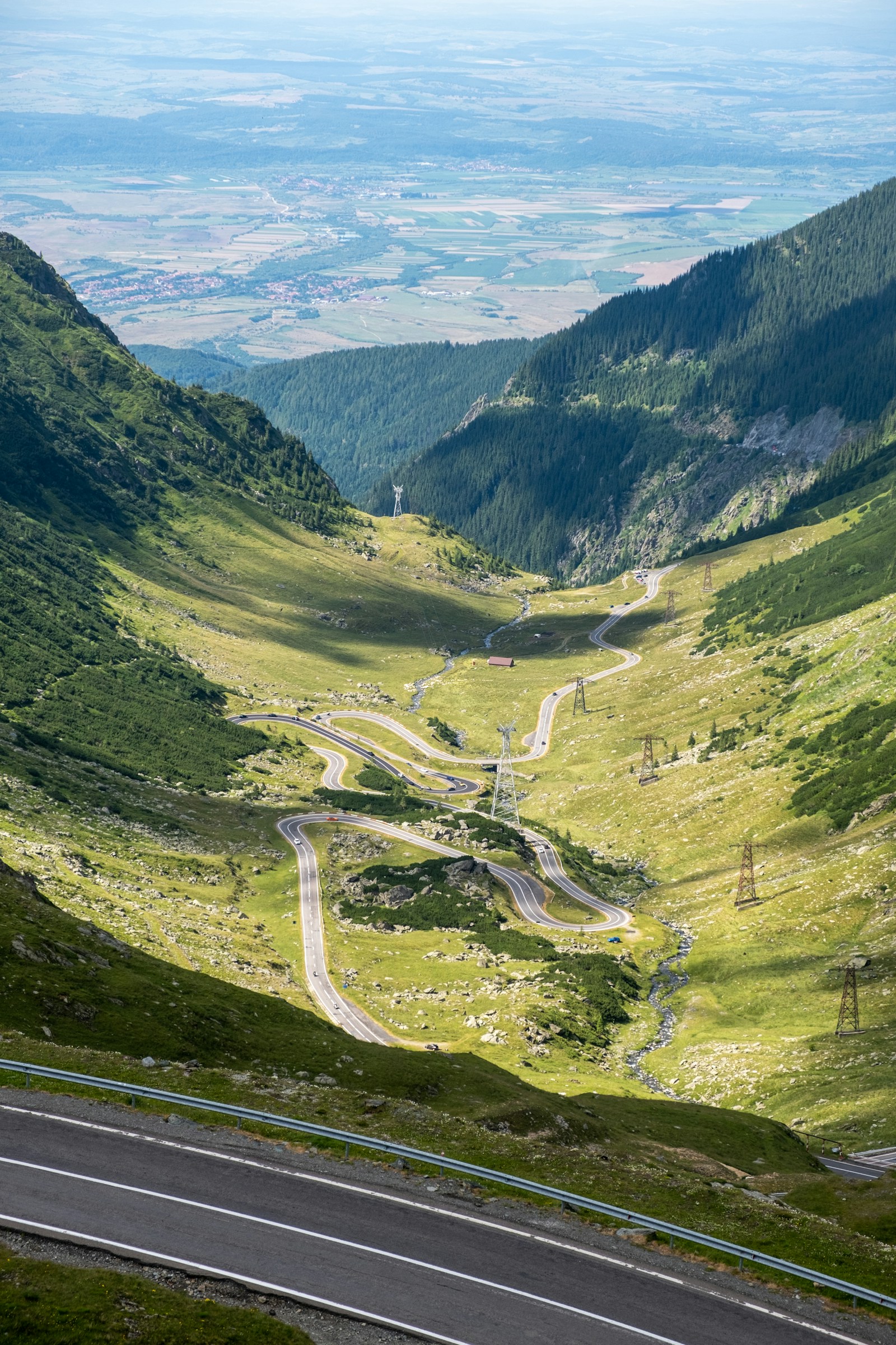 The winding Transfagarasan road snaking down a green Carpathian valley in Romania