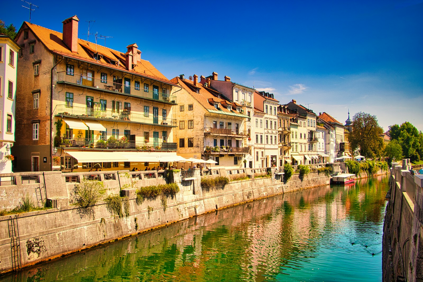 Pastel townhouses and cafes along the Ljubljanica river in Ljubljana