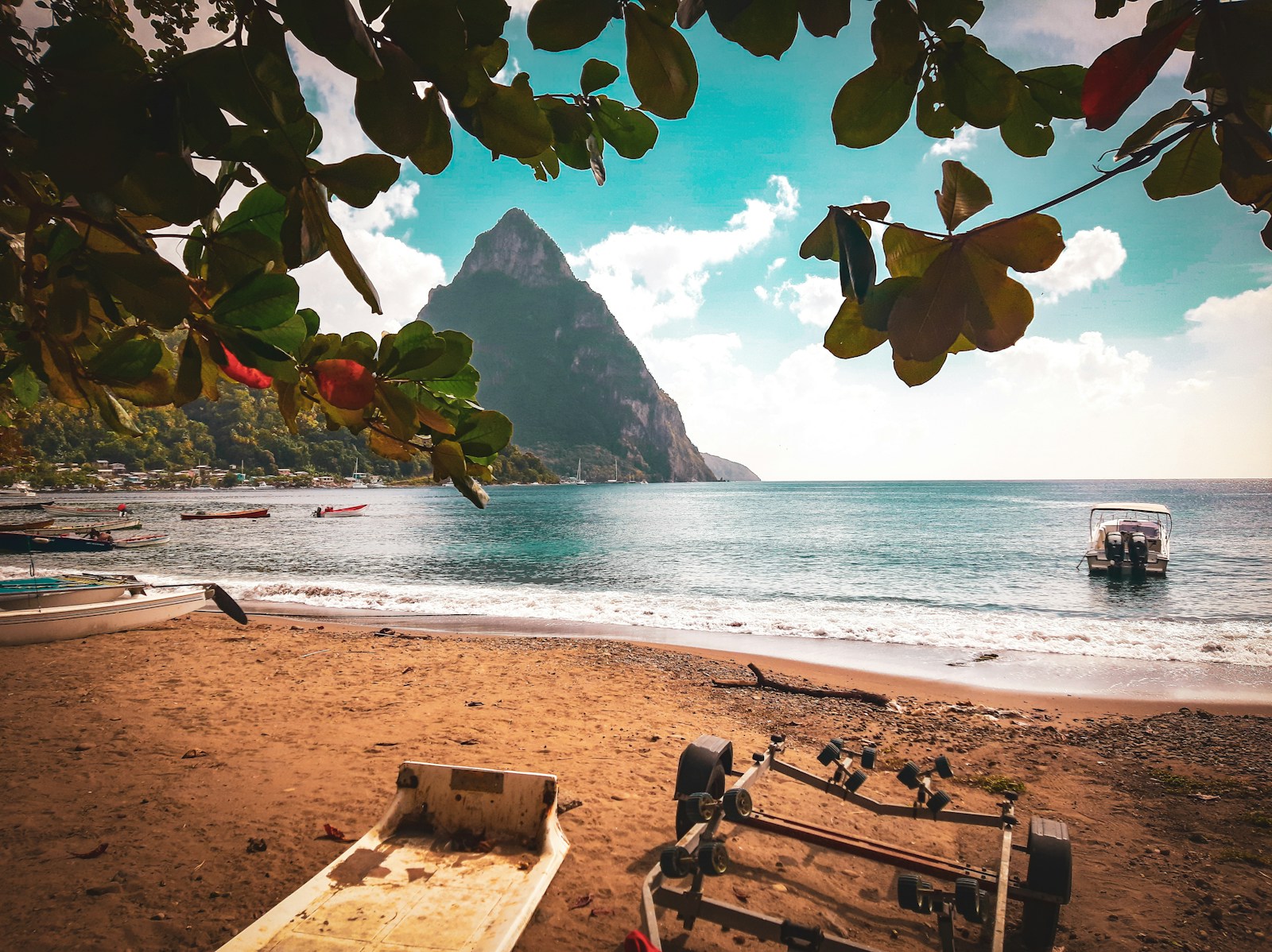A Piton framed above a beach with fishing boats near Soufriere, St Lucia