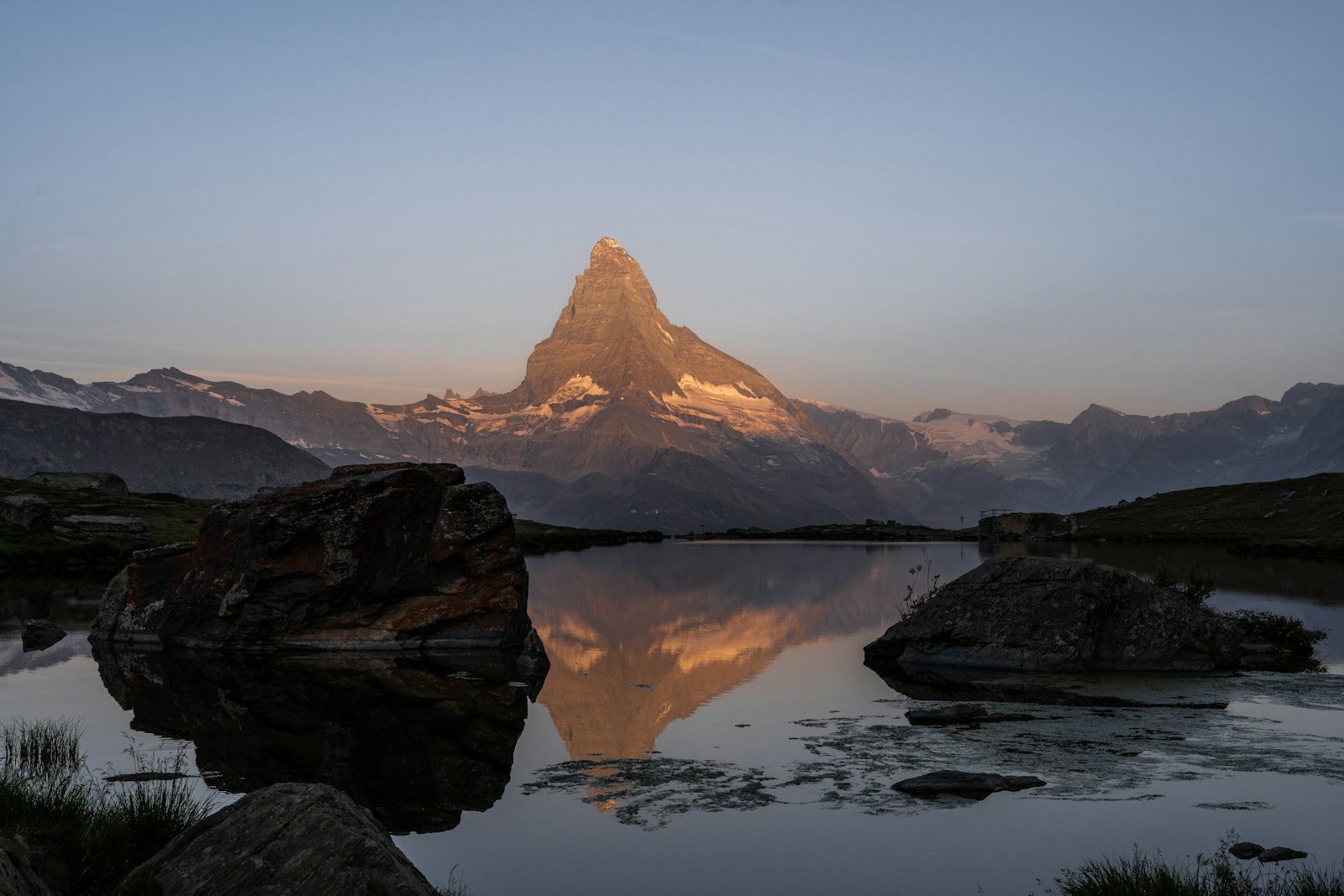 The Matterhorn glowing at dawn, reflected in an alpine lake above Zermatt