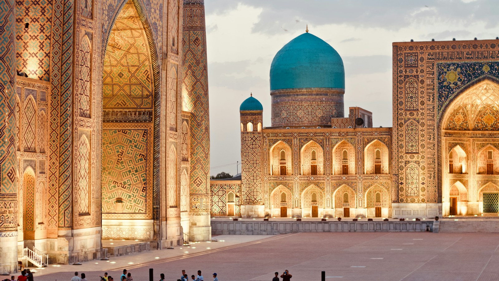 The turquoise dome and tiled madrasa portals of the Registan in Samarkand at golden hour